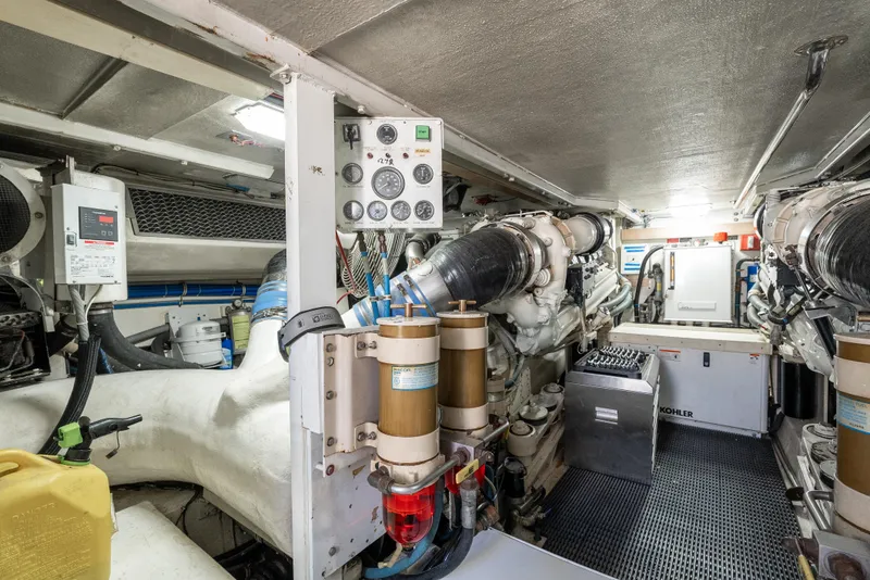 Slide: The Image of Engine room of 2000 Hatteras 70 Convertible yacht, showcasing machinery and equipment. - 50