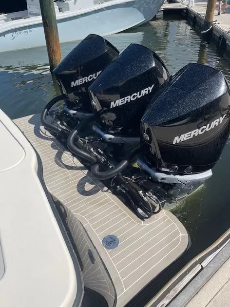 Slide: The Image of 2022 Scout 355 LXF CC with triple Mercury outboard engines at dock. - 6