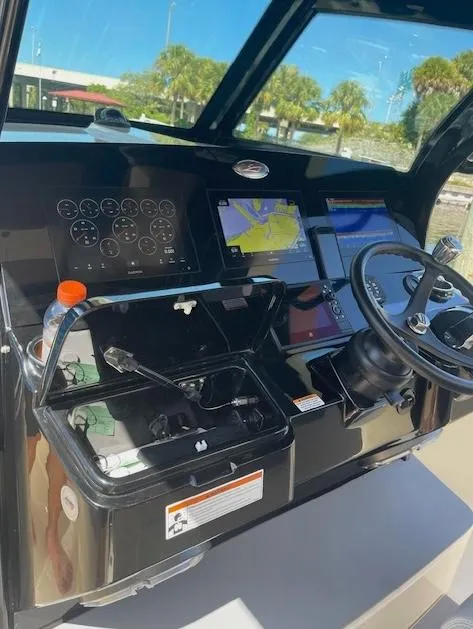 Slide: The Image of 2022 Scout 355 LXF CC boat dashboard with navigation screens and steering wheel. - 8