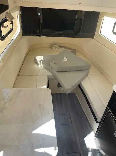 Slide: The Image of Interior of 2022 Scout 355 LXF CC boat, featuring seating and table. - 9