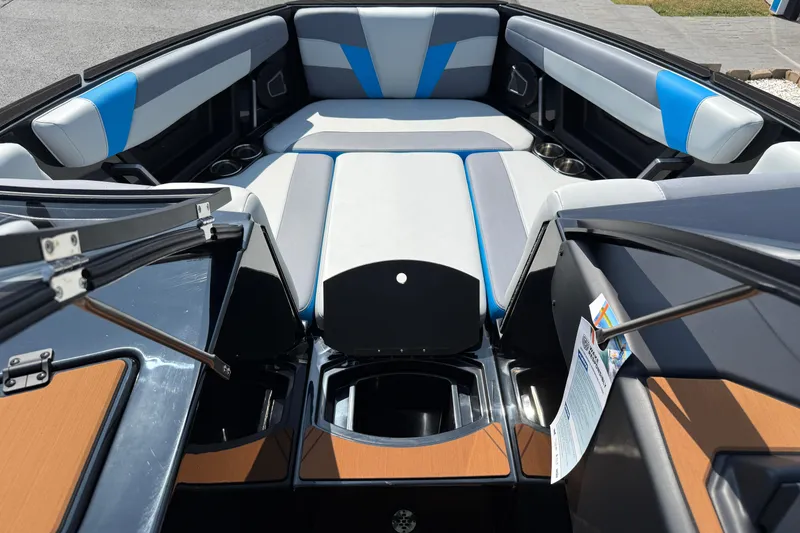 Slide: The Image of 2026 Axis T250 boat interior with blue and gray seating, open compartments, and cup holders. - 19