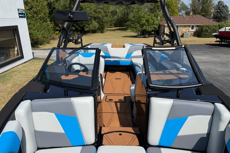 Slide: The Image of 2026 Axis T250 boat interior with blue and gray seating, parked outdoors. - 20