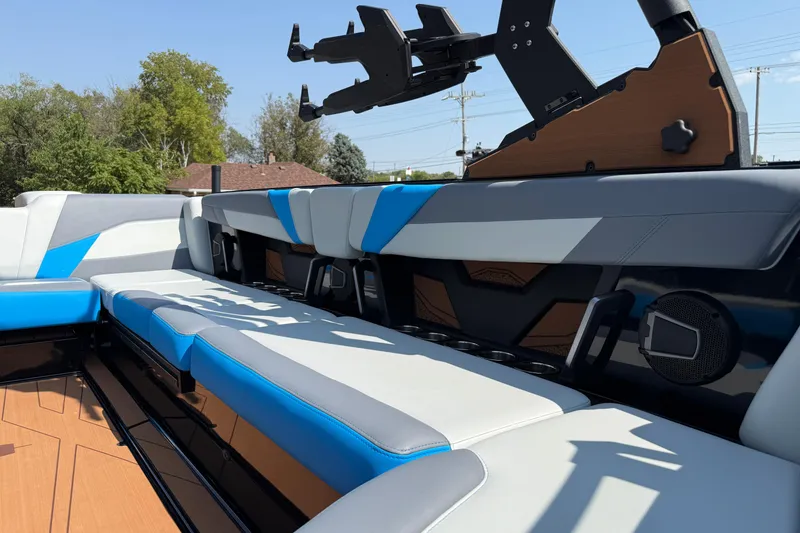 Slide: The Image of 2026 Axis T250 boat interior with blue and white seating, speaker, and wakeboard rack. - 22