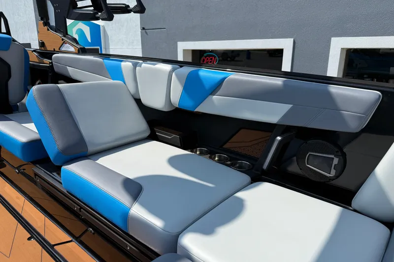 Slide: The Image of 2026 Axis T250 boat interior with blue and gray seating, cup holders, and speaker. - 25