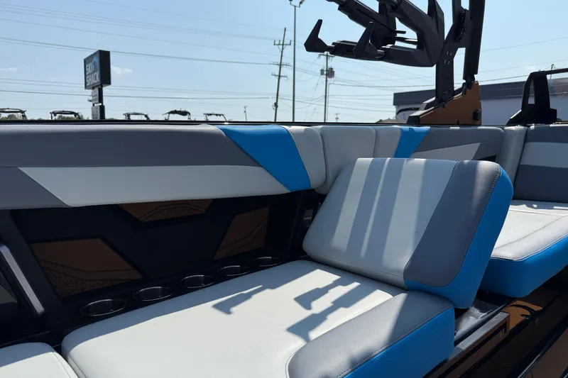 Slide: The Image of 2026 Axis T250 boat interior with blue and gray seating, cup holders, and sleek design. - 26