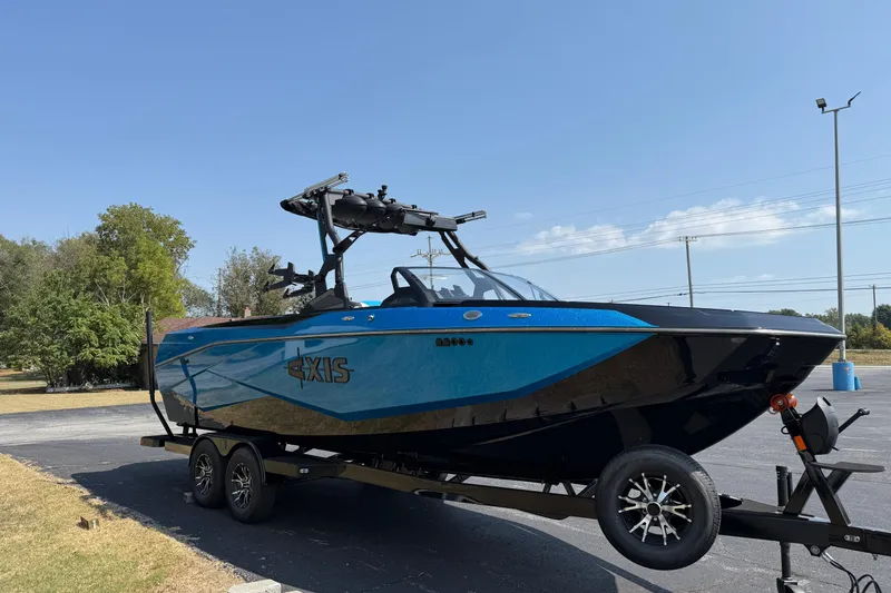 Slide: The Image of 2026 Axis T250 boat on trailer, blue and black design, parked outdoors. - 3