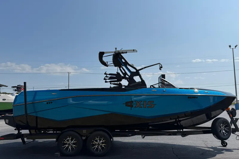 Slide: The Image of 2026 Axis T250 boat in blue on a trailer under a clear sky. - 4