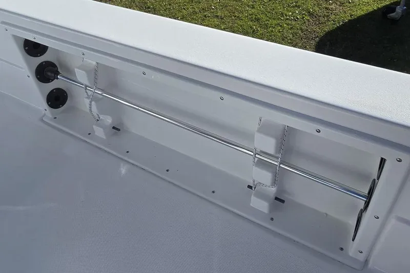 Slide: The Image of 2026 NauticStar 224 Bay boat interior detail with rod holders and storage compartment. - 11