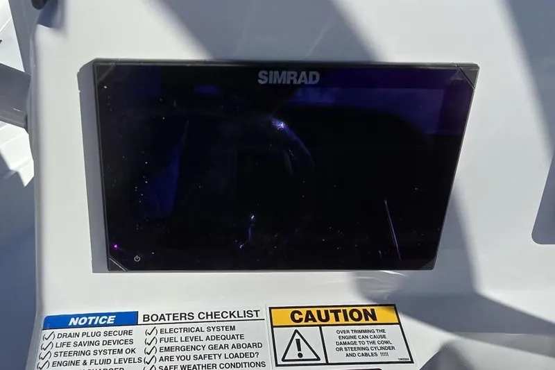 Slide: The Image of Simrad display on 2026 NauticStar 224 Bay boat with safety checklist and caution labels. - 15