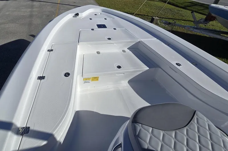 Slide: The Image of 2026 NauticStar 224 Bay boat interior with white seating and storage compartments. - 20