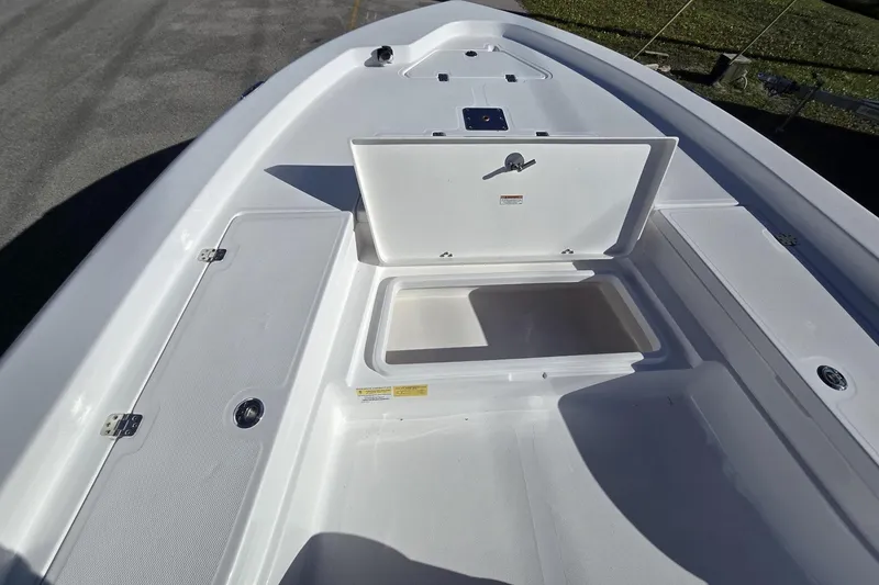 Slide: The Image of 2026 NauticStar 224 Bay boat with open storage compartment on deck. - 21