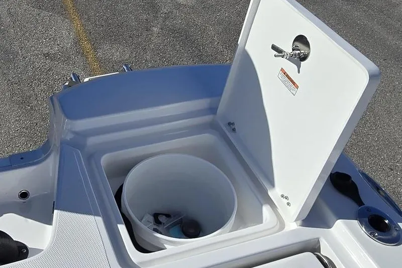 Slide: The Image of Open storage compartment on 2026 NauticStar 224 Bay boat, featuring a white bucket inside. - 7