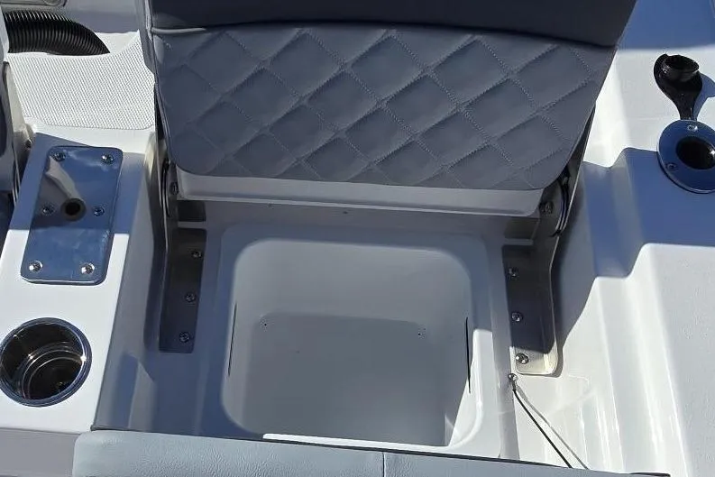 Slide: The Image of 2026 NauticStar 224 Bay boat seat with storage compartment and cup holder. - 9