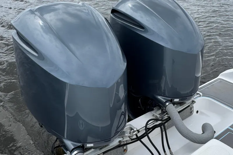 Slide: The Image of Twin outboard motors on a 2013 SeaHunter 33 Tournament boat, docked on water. - 19