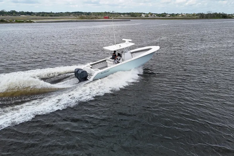 Slide: The Image of 2013 SeaHunter 33 Tournament boat cruising on a scenic waterway. - 2
