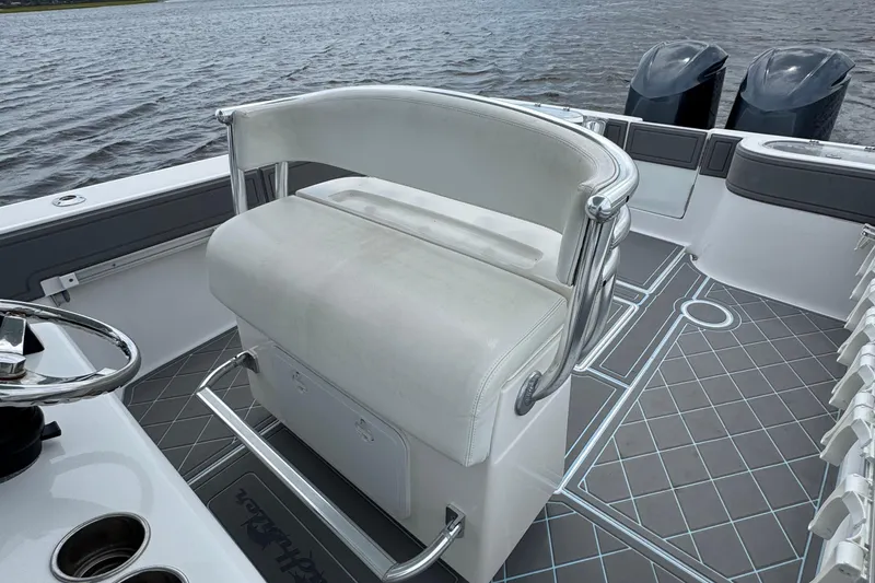 Slide: The Image of 2013 SeaHunter 33 Tournament boat interior with helm seat and dual engines on water. - 35
