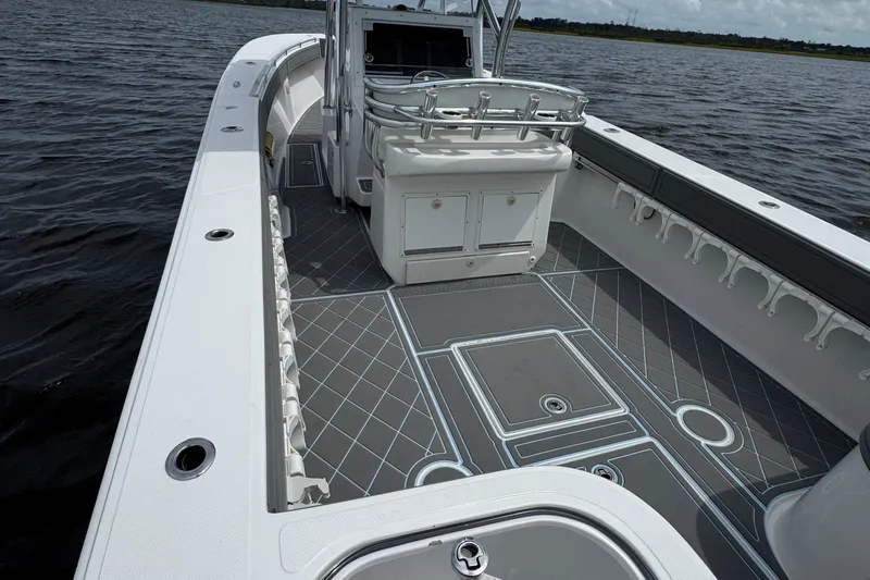 Slide: The Image of 2013 SeaHunter 33 Tournament boat with spacious deck and rod holders on calm water. - 39