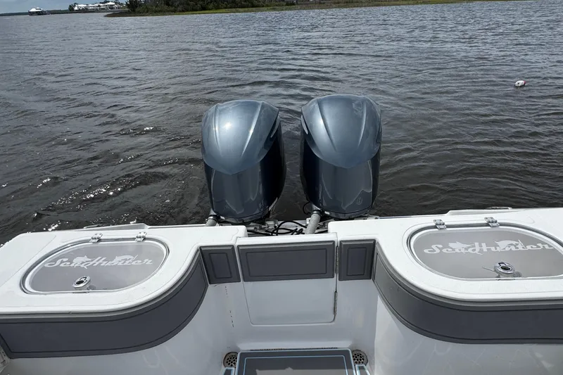 Slide: The Image of 2013 SeaHunter 33 Tournament boat with dual outboard motors on a calm waterway. - 40