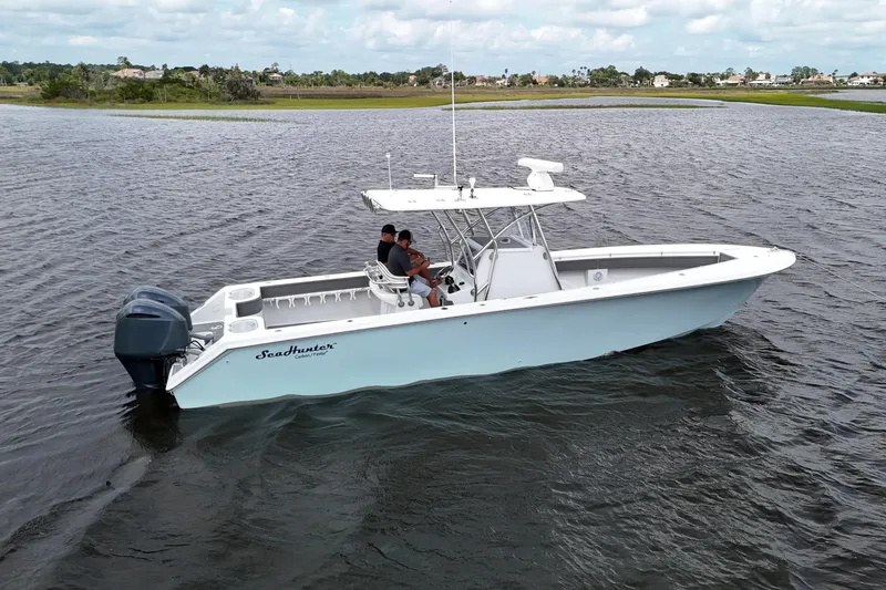 Slide: The Image of 2013 SeaHunter 33 Tournament boat anchored on calm water with two people onboard. - 5