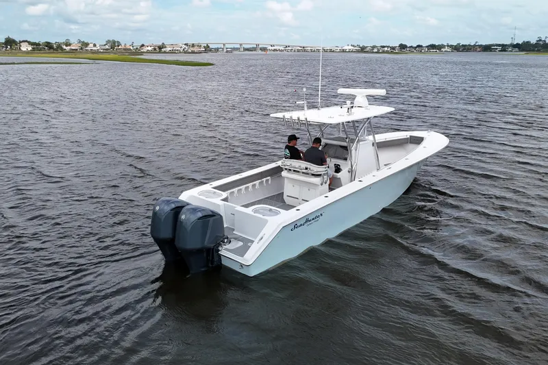 Slide: The Image of 2013 SeaHunter 33 Tournament boat on calm water, featuring twin outboard engines. - 6