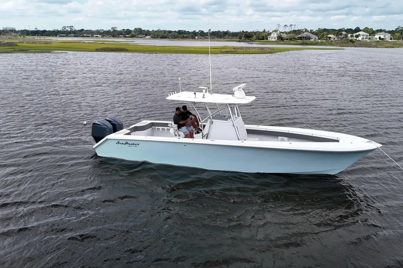 Slide: The Image of 2013 SeaHunter 33 Tournament boat on water, featuring dual engines and center console. - 9