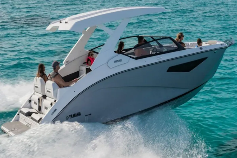 Slide: The Image of 2027 Yamaha Boats 295SD cruising on clear turquoise waters with passengers onboard. - 8