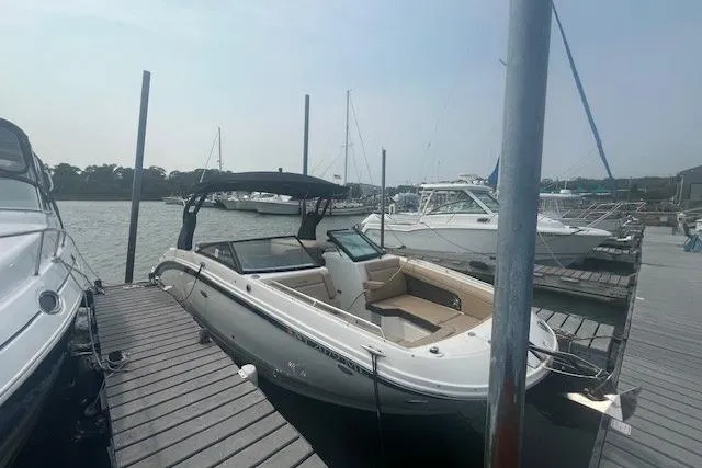Slide: The Image of 2019 Sea Ray SDX 270 boat docked at a marina under a clear sky. - 1