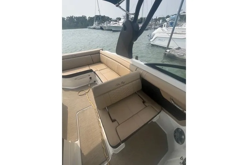 Slide: The Image of 2019 Sea Ray SDX 270 boat interior with beige seating, docked at marina. - 10
