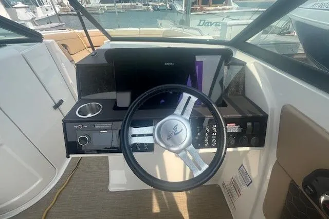 Slide: The Image of 2019 Sea Ray SDX 270 helm with steering wheel and control panel, docked at marina. - 12