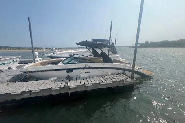 Slide: The Image of 2019 Sea Ray SDX 270 boat docked on a sunny day by the water. - 14