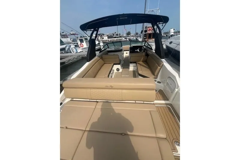 Slide: The Image of 2019 Sea Ray SDX 270 boat with spacious tan seating and sleek design at a marina. - 7