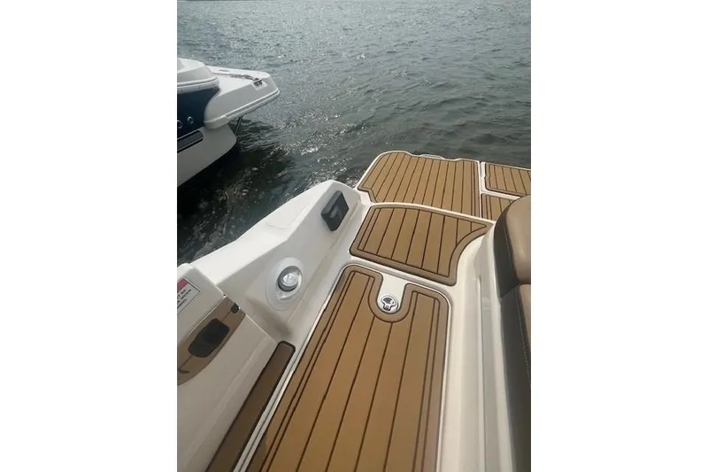 Slide: The Image of 2019 Sea Ray SDX 270 boat deck with teak-style flooring on the water. - 9