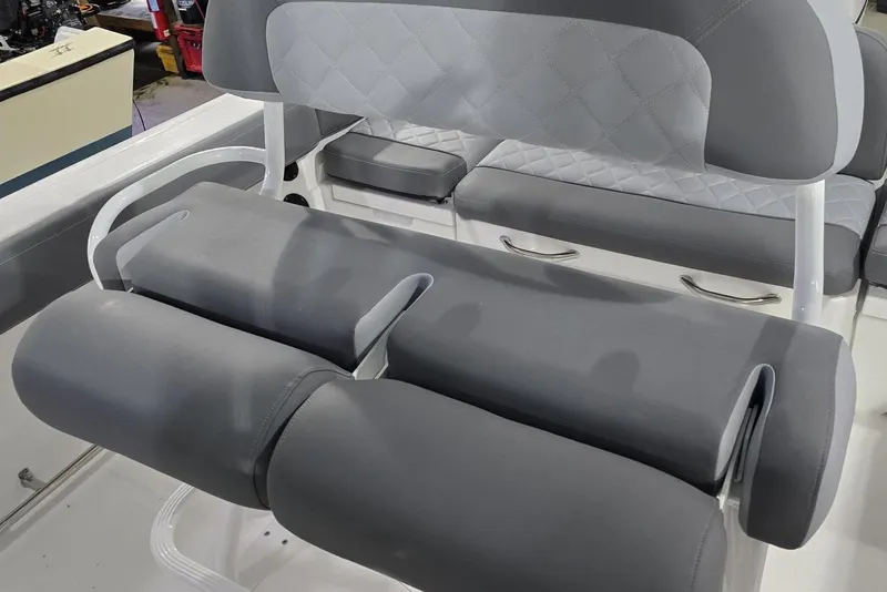 Slide: The Image of 2026 NauticStar 242L Offshore boat seating with gray cushioned upholstery. - 12