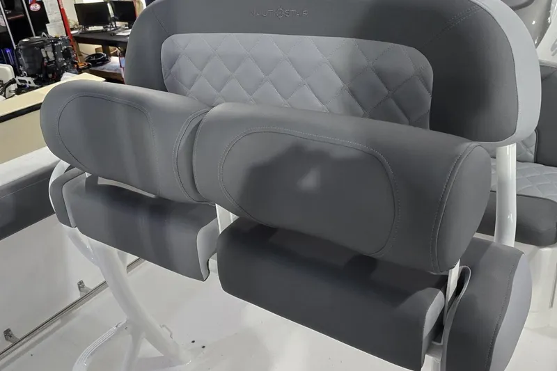 Slide: The Image of 2026 NauticStar 242L Offshore boat seating with gray upholstery and diamond stitching. - 13