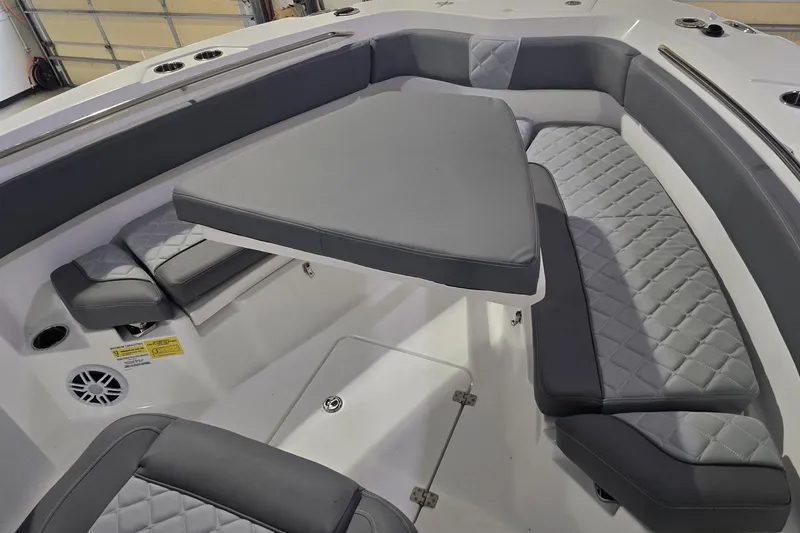Slide: The Image of 2026 NauticStar 242L Offshore boat interior with gray cushioned seating and table. - 20