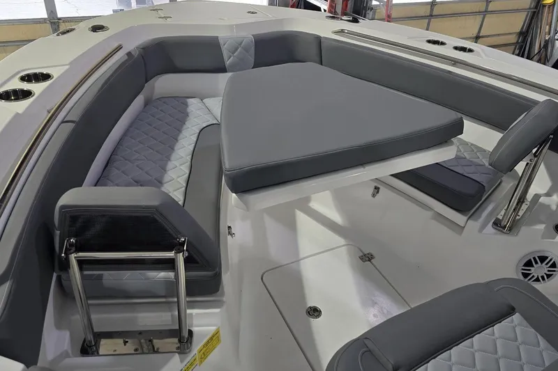 Slide: The Image of 2026 NauticStar 242L Offshore boat interior with gray cushioned seating and table. - 21