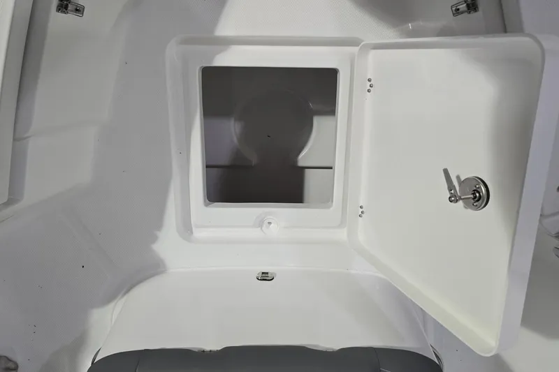 Slide: The Image of Open storage compartment on 2026 NauticStar 242L Offshore boat, featuring a secure latch. - 23