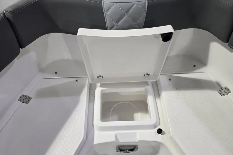 Slide: The Image of 2026 NauticStar 242L Offshore boat storage compartment with open lid, showcasing interior space. - 24