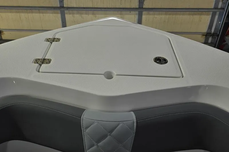 Slide: The Image of 2026 NauticStar 242L Offshore boat interior with storage compartment and cushioned seating. - 25