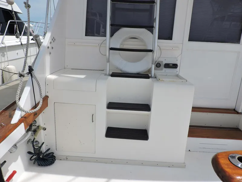 Slide: The Image of 1990 Post 44 Sport Fisherman boat deck with ladder and storage compartments. - 11