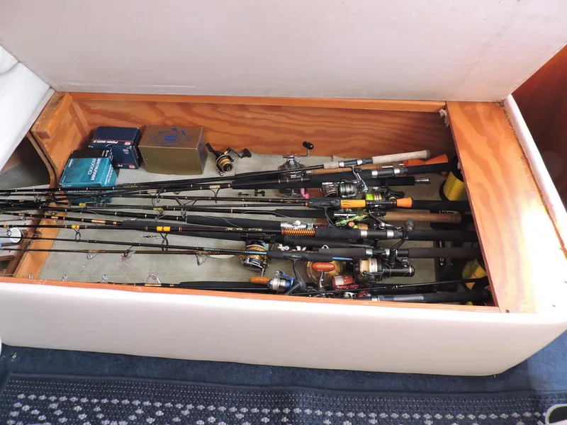 Slide: The Image of Fishing rods and gear stored in a compartment on a 1990 Post 44 Sport Fisherman boat. - 26