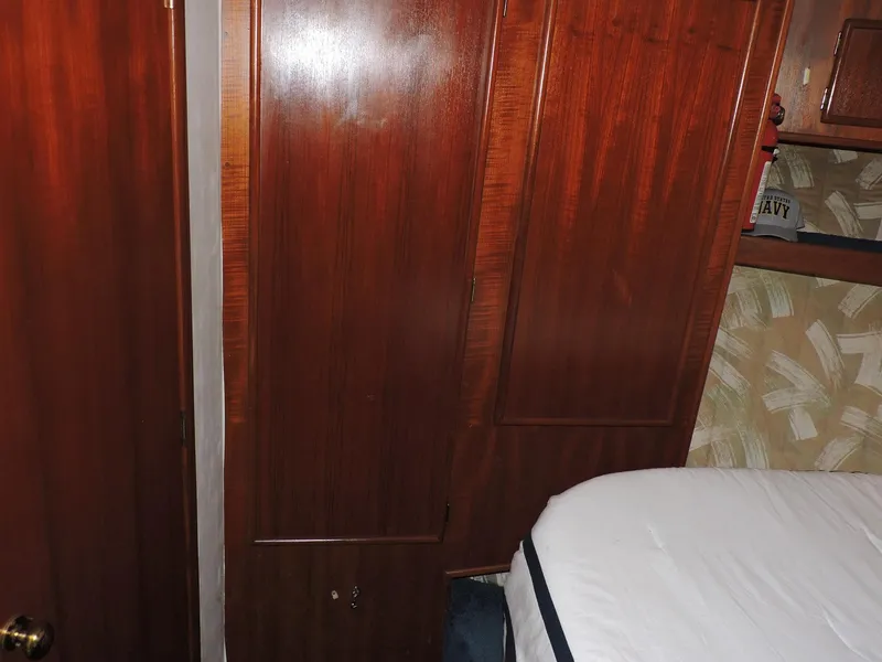 Slide: The Image of Interior of 1990 Post 44 Sport Fisherman with wooden cabinets and bed. - 38