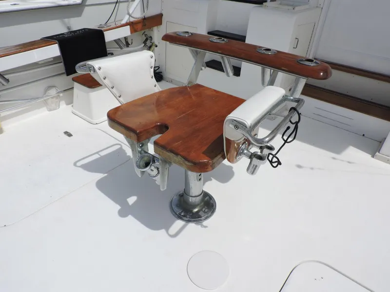 Slide: The Image of Fishing chair on 1990 Post 44 Sport Fisherman boat deck, featuring rod holders and wooden seat. - 6
