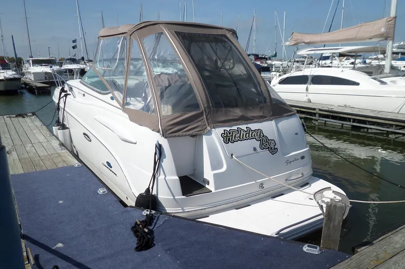 Slide: The Image of 2005 Chaparral Signature 270 boat docked at marina, featuring a covered cockpit. - 2