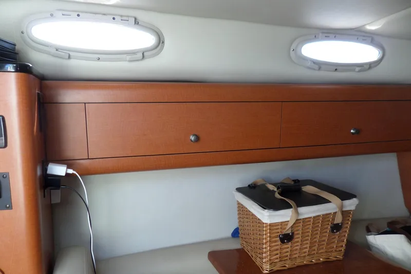 Slide: The Image of 2005 Chaparral Signature 270 cabin interior with wooden cabinets and wicker basket. - 33