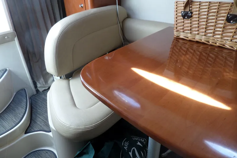 Slide: The Image of Interior of 2005 Chaparral Signature 270 with wooden table and beige seating. - 36