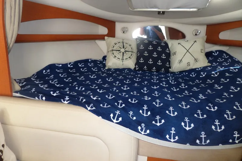 Slide: The Image of 2005 Chaparral Signature 270 cabin interior with nautical-themed bedding and decorative pillows. - 39