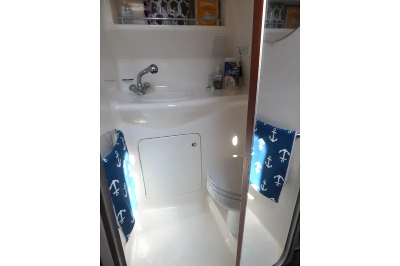 Slide: The Image of 2005 Chaparral Signature 270 bathroom with sink, toilet, and nautical-themed towels. - 49