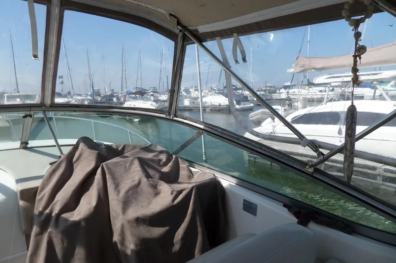 Slide: The Image of 2005 Chaparral Signature 270 boat interior with marina view, covered seating, and clear windows. - 64