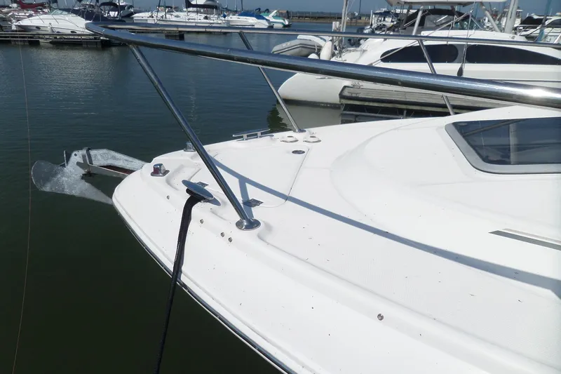 Slide: The Image of 2005 Chaparral Signature 270 boat docked in marina, featuring sleek white deck and railing. - 66